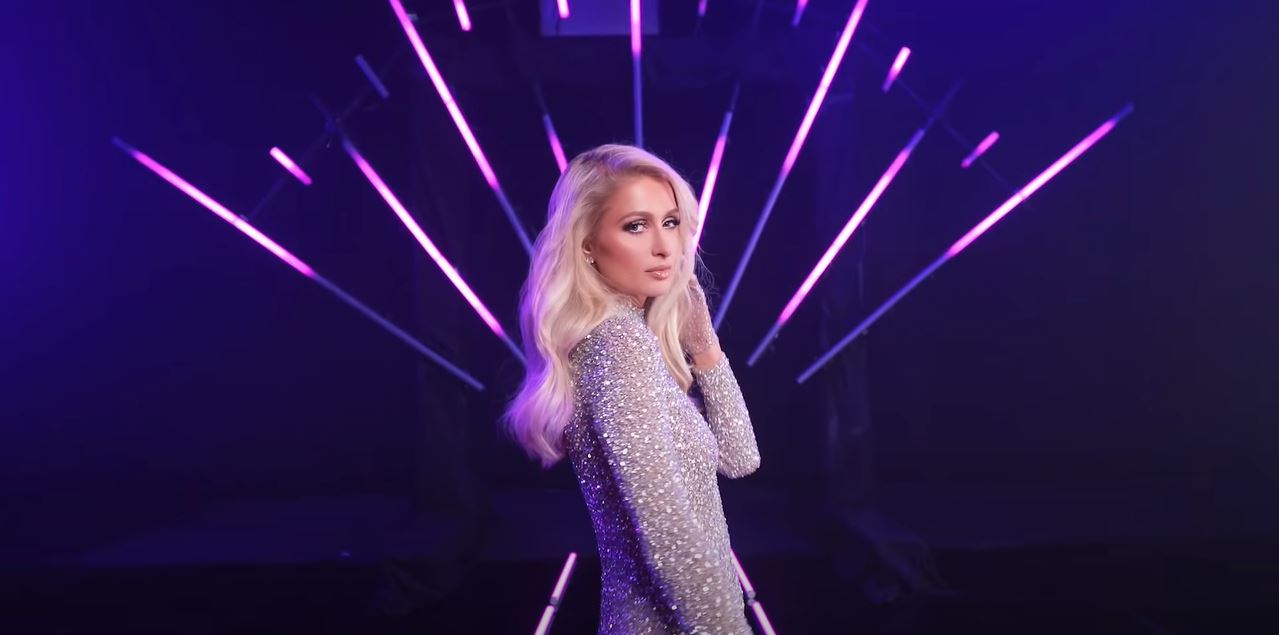Paris Hilton wears a glittery bodysuit while appearing in a music video.
